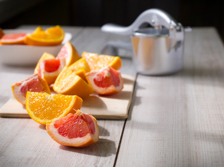 Fresh citrus fruits with traditional manual juicer on a wooden table  の写真素材