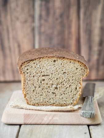 Homemade whole grain mixed rye-wheat sourdough bread on a cutting board.
