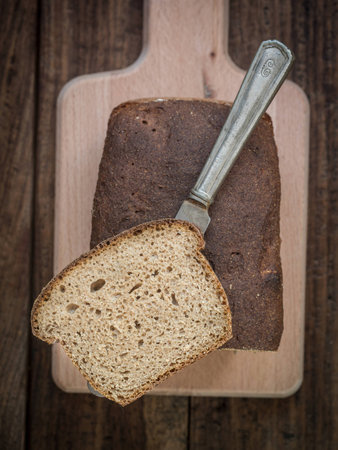 Homemade whole grain mixed rye-wheat sourdough bread on a cutting board.