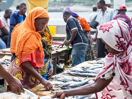 Local women buying seafood in the fish market in Dar es Salaam, Tanzania in East Africa on Sunday. Landscape orientation.のeditorial素材