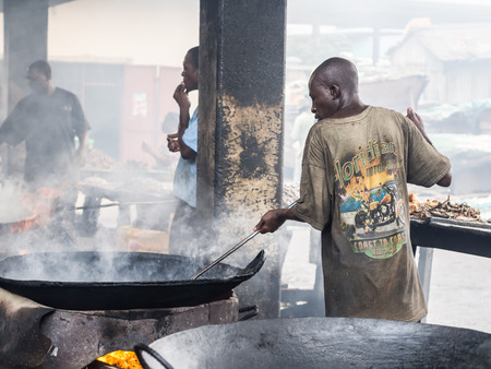 Local people frying fish on the fish market in the port in Dar es Salaam, Tanzania, East Africa, on a weekend. Horizontal orientation.のeditorial素材