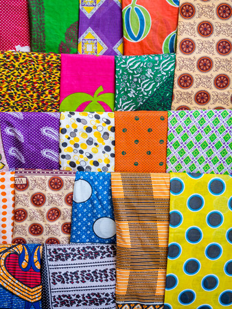 Colorful African garments called kanga and kitenge traditionally worn by women in East Africa, sold on a local market in Stone Town, Zanzibar, Tanzania.の写真素材