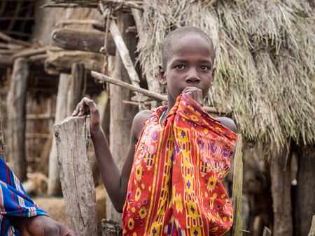 Maasai boy in traditional outfit in his boma village in Tanzania, Africa.のeditorial素材