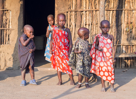 Maasai children in front of a traditional house in their boma village in Tanzania, Africa.のeditorial素材