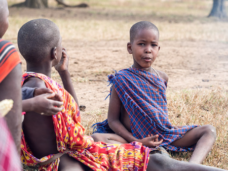 HANDENI, TANZANIA - AUGUST 01, 2015: Maasain children sitting next to a fire in their boma village in Tanzania, Africa.のeditorial素材