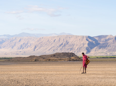 Maasai warrior wearing traditional red clothes in the dried part of Lake Natron in the North of Tanzania, Africa.のeditorial素材