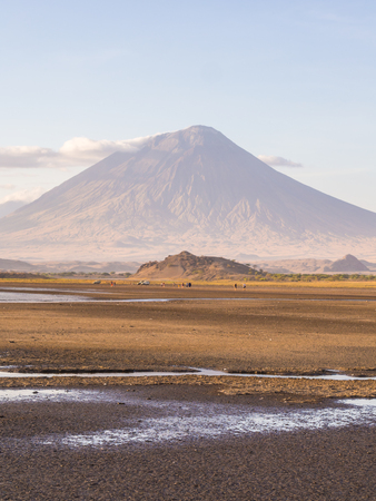 Ol Doinyo Lengai Mountain of God in the Maasai language, an active volcano in the Northen Tanzania, seen from the dried Lake Natron at sunset in October.の写真素材