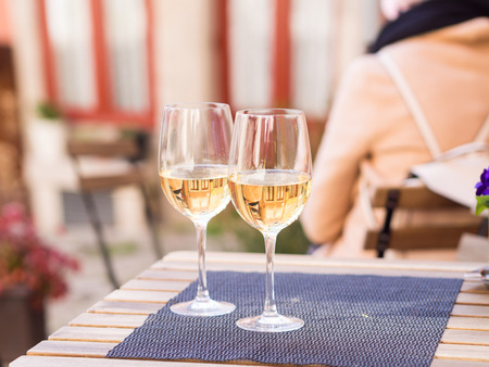 Two glasses of white wine served in a small cafe in the Old Town of Porto, Portugal.の写真素材