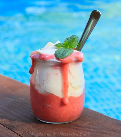Strawberry dessert on wooden plank against swimming poolの写真素材