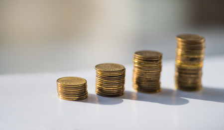 Stack of coins on the green backgroundの写真素材