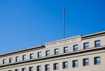 Poznan, Poland - February 12th 2022: Courthouse building against blue sky. Inscription "Justicia Omnibus Fiat" means "Let justice be done to all"のeditorial素材