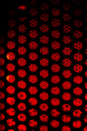 Illuminated perforated sheet metal close up.