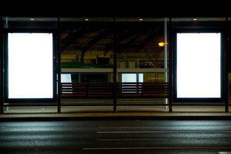 Outdoor advertising billboards at tramway stop at nighttime in the city.の写真素材