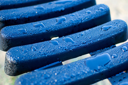 Plastic bench covered with morning dew.の写真素材