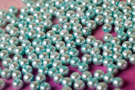a scattering of blue pearls on a pink backgroundの写真素材
