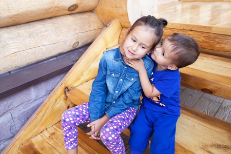 Boy and girl playing outdoors in a park near the houseの写真素材
