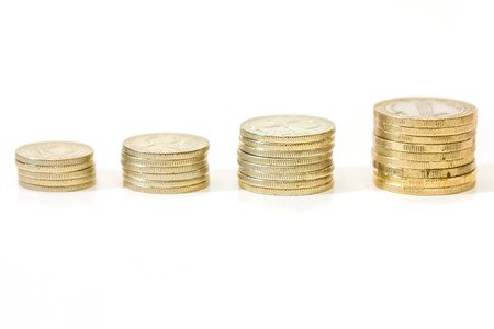 Money growth concept, where small coins in a pile gets bigger and higher for each pile.