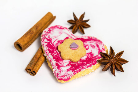 Heart shaped cookie decorated with cinnamon and star anise isolated on white