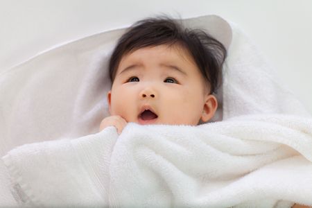 A baby looks surprised.の写真素材