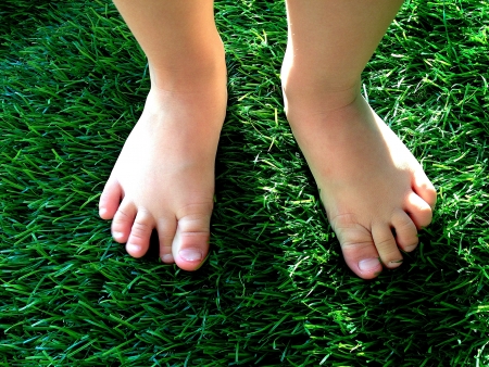 Boy feet on grassの写真素材