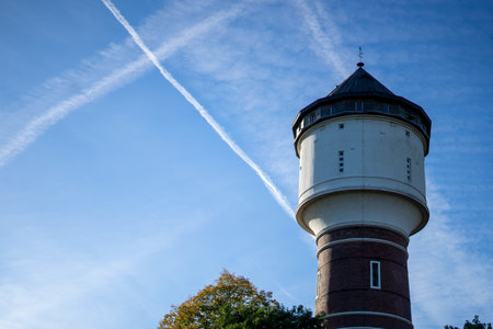 Water tower against a blue sky with white clouds on a sunny dayの写真素材
