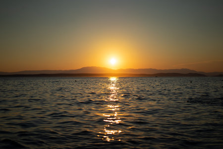 Sunset over the sea. The sun is reflected in the water.の写真素材