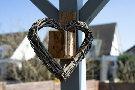 Heart-shaped wooden padlock on a metal fence in the villageの写真素材