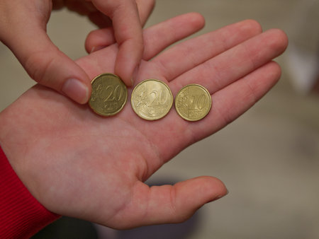 Euro coins in the hands of a child. The concept of saving money.