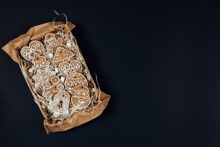Christmas gingerbread cookies with glaze in the present box in rustic style isolated on black...