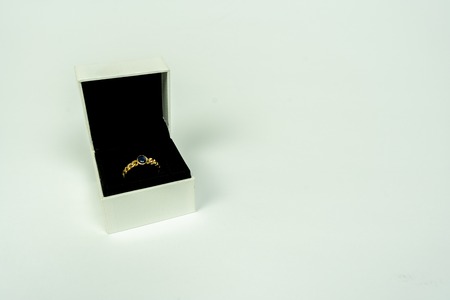 Beautiful golden ring with blue gemstone in the white box isolated on white background. Luxurious engagement ring. Giftの写真素材