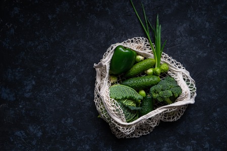 Top view of fresh green vegetables in textile grocery mesh bag. Reusable shopping bag. Healthy vegetarian food.の写真素材