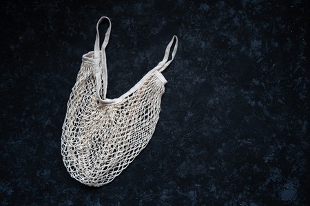 Shopping mesh bag isolated on a black background. Wicker reusable grocery bag. Eco. Zero wasteの写真素材