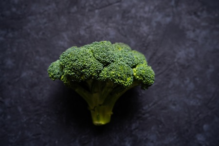 Fresh raw green broccoli on a black stone table. Flat lay. Top view. Free copy space. Healthy foodの写真素材
