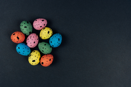 Group of colorful painted Easter quail eggs isolated on black background. Copy space. Easter holiday concept. Flat layの写真素材