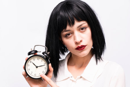 A business woman holding an alarm clock