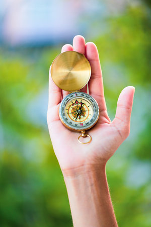 hand holding a compass in nature