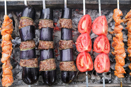 Eggplant kebab and chicken skewers cooked over coal fireの写真素材