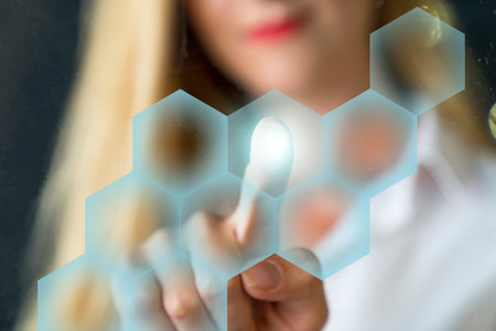 Person touching an hexagonal button on a digital interface