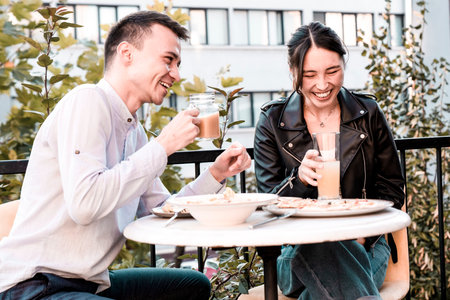 Happy young couple having lunch at outdoors restaurantの写真素材