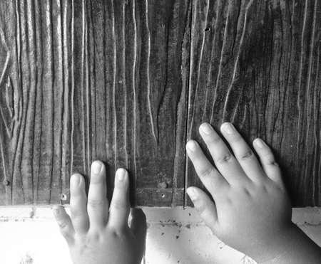 OCTOBER 5, 2020 Photo of baby's hands in front of natural wood backgroundの写真素材