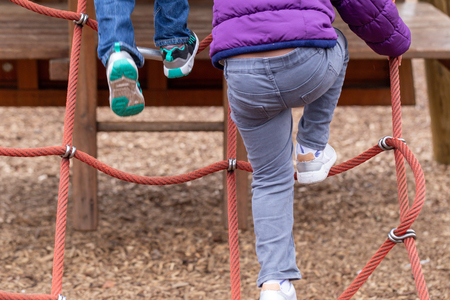 Young children playing on a climbing frameの写真素材