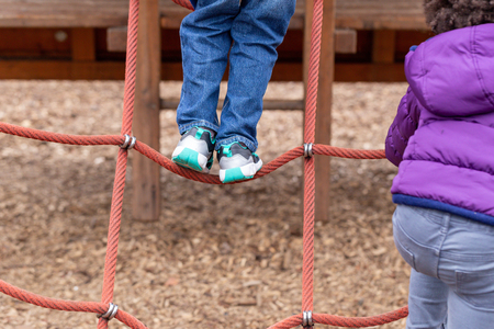 Young children playing on a climbing frameの写真素材