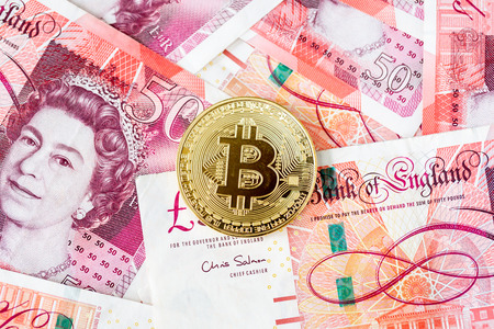 Bitcoin with a pile of fifty pound sterling bank notesの写真素材