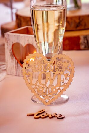 Love concept.  Champagne glass with love text and heart shapes on accessories in a wedding settingの写真素材