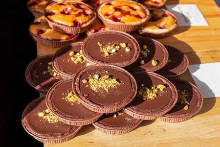 Chocolate and pistachio tarts on display on a market stall in the UKの写真素材