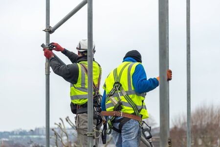 Professional Scaffolders erecting scaffolding on a building in the UKの写真素材