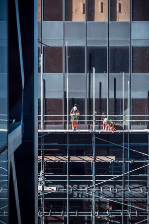 London, England - February 16 2018: Construction workers on a high scaffold on a building site in central London, UKのeditorial素材