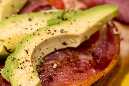 Bacon, avocado, cheese and tomato open sandwichの写真素材