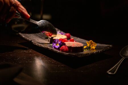 Indulgent, stylish chocolate based dessert decorated with colourful flowers. With copy space