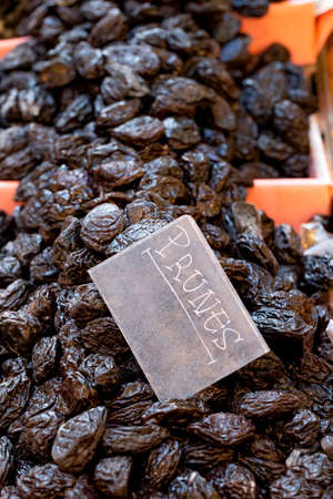 Organic, healthy prunes, dried plums, on display for sale on a market stall